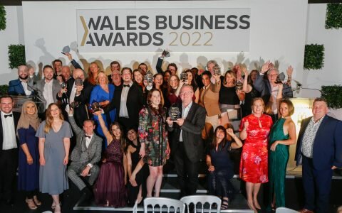 People in evening wear celebrate award wins on stage