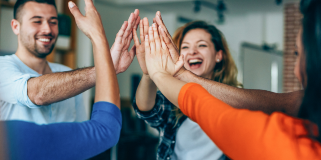 A group of men and women high fiving.
