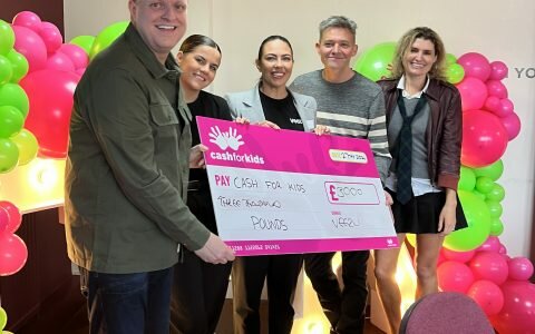 Group of people standing with a cheque